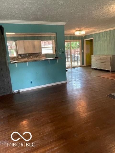 5802 Bertha St, Indianapolis, IN 46241 - unfurnished living room featuring ornamental molding, a textured ceiling, wood finished floors, and baseboards