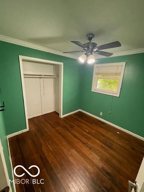 5802 Bertha St, Indianapolis, IN 46241 - unfurnished bedroom with hardwood / wood-style floors, baseboards, crown molding, ceiling fan, and a closet