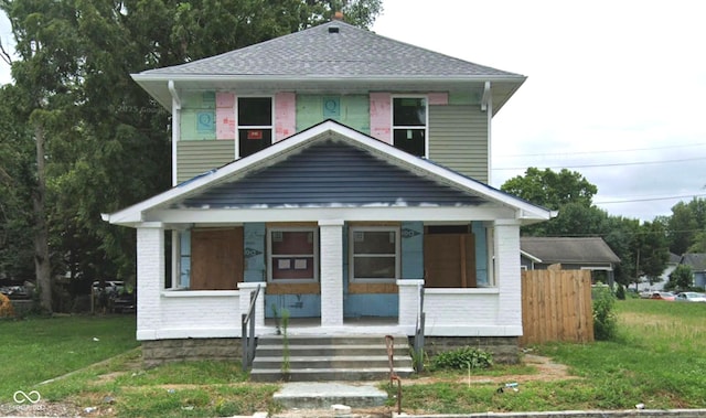 2623 E Michigan St, Indianapolis, IN 46201 - american foursquare style home with covered porch, a front lawn, roof with shingles, and brick siding
