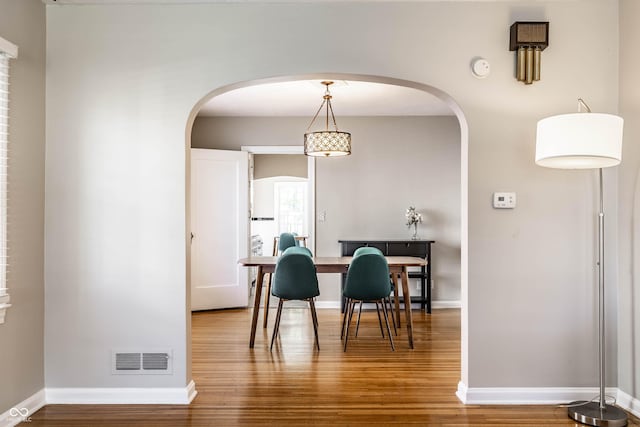 5428 E 10th St, Indianapolis, IN 46219 - dining area featuring wood finished floors, arched walkways, and baseboards