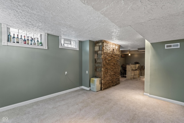 2134 N Alabama St, Indianapolis, IN 46202 - below grade area featuring carpet floors, baseboards, a bar, and a textured ceiling