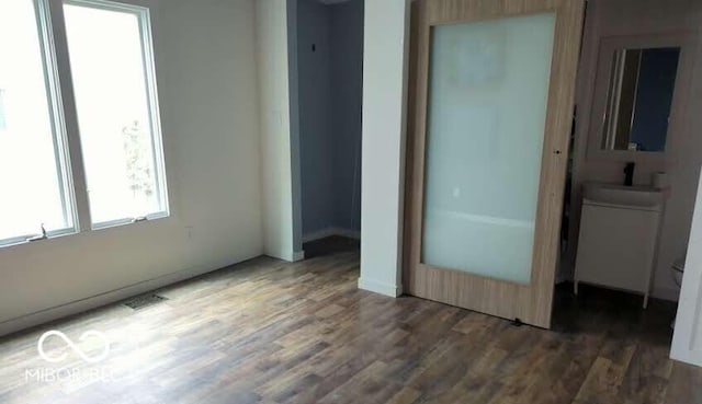 unfurnished bedroom with wood finished floors and baseboards