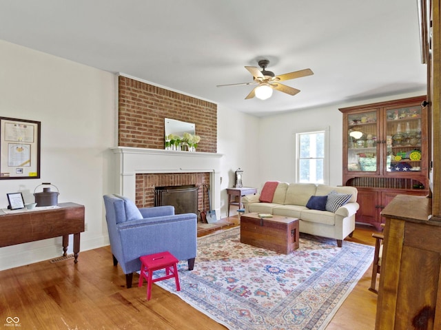 19702 Centennial Rd, Sheridan, IN 46069 - living room featuring ceiling fan, light wood finished floors, and a brick fireplace