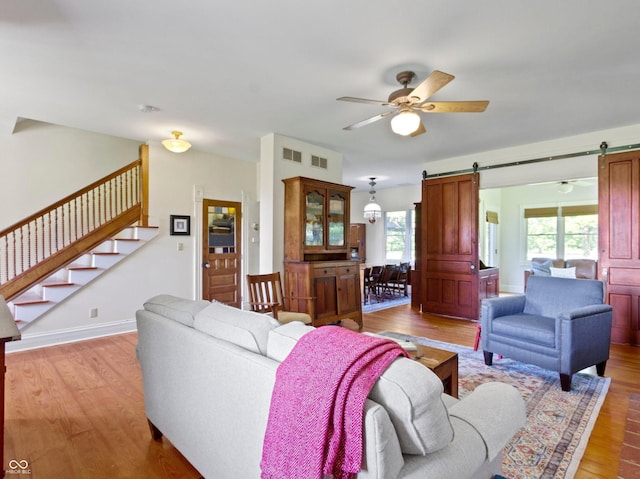 19702 Centennial Rd, Sheridan, IN 46069 - living room featuring a barn door, wood finished floors, a ceiling fan, and stairway