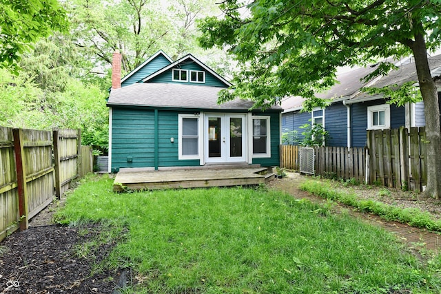 631 Prospect St, Indianapolis, IN 46203 - rear view of property with french doors, a chimney, a wooden deck, a shingled roof, and a fenced backyard