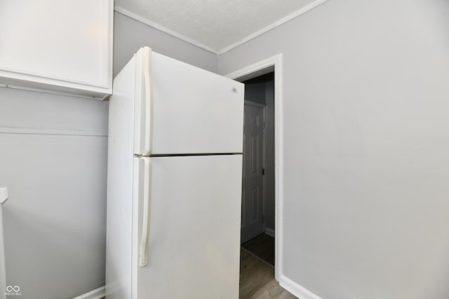 2966 N Olney St, Indianapolis, IN 46218 - kitchen featuring freestanding refrigerator, light wood finished floors, white cabinetry, and baseboards