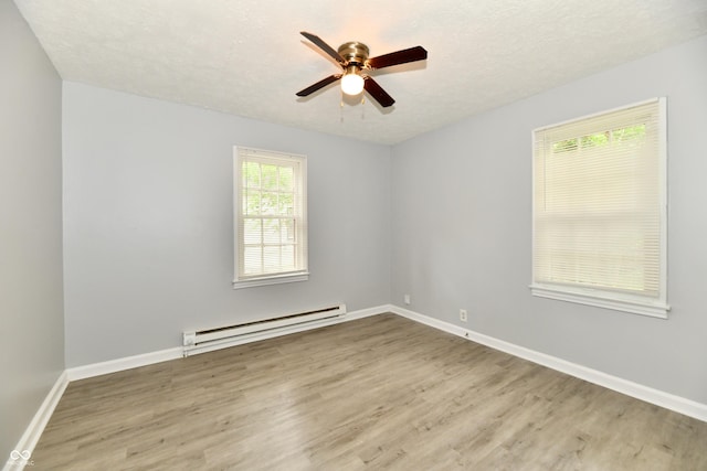 2966 N Olney St, Indianapolis, IN 46218 - spare room featuring baseboard heating, wood finished floors, ceiling fan, and baseboards