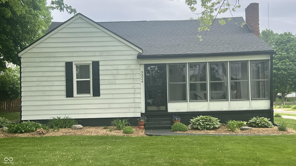 3324 S Walnut St, Muncie, IN 47302 - rear view of property with roof with shingles, a yard, a sunroom, and a chimney