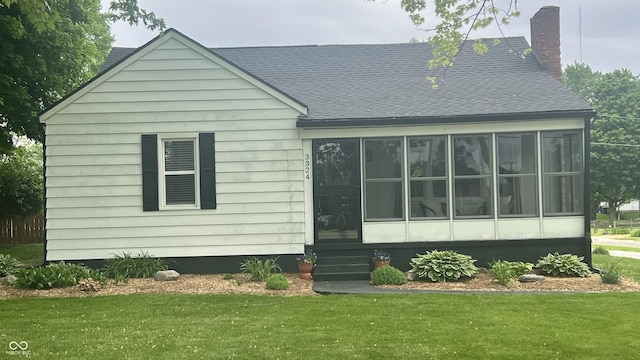 3324 S Walnut St, Muncie, IN 47302 - rear view of property with roof with shingles, a yard, a sunroom, and a chimney