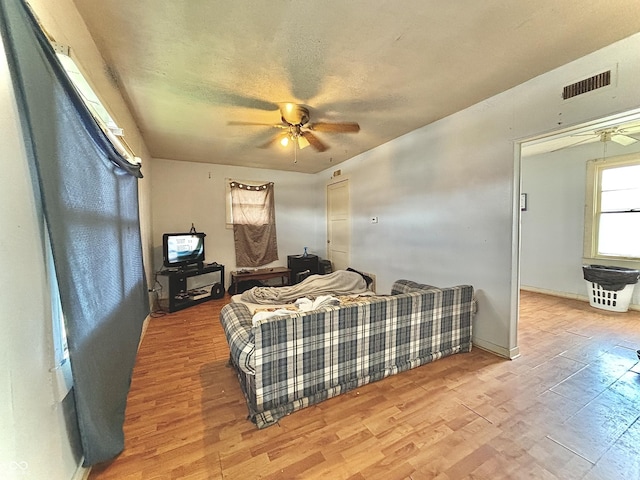 living area featuring a ceiling fan, wood finished floors, and baseboards