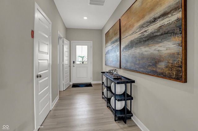 entryway with baseboards, light wood-style flooring, and recessed lighting