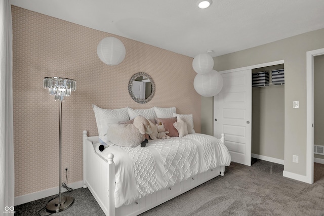 bedroom with baseboards, carpet, and a closet