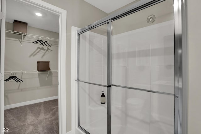 full bathroom with a shower stall, a walk in closet, and recessed lighting