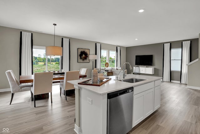 kitchen with stainless steel dishwasher, a sink, open floor plan, plenty of natural light, and recessed lighting