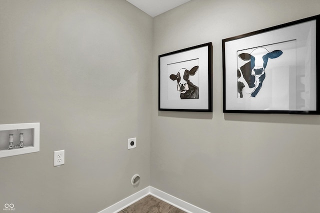 clothes washing area with hookup for an electric dryer, washer hookup, and baseboards