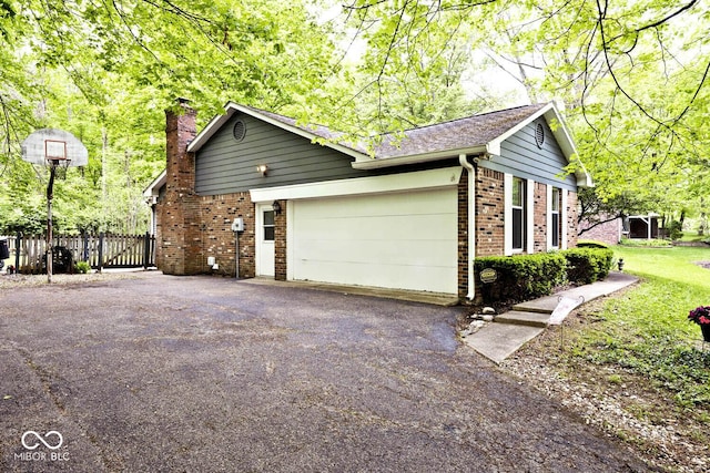 19446 Ethan Allen Ln, Westfield, IN 46074 - view of side of property featuring driveway, a garage, a chimney, brick siding, and fence