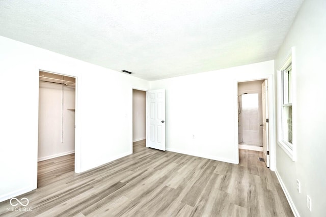 19446 Ethan Allen Ln, Westfield, IN 46074 - unfurnished bedroom featuring light wood-style flooring, a closet, connected bathroom, a textured ceiling, and baseboards