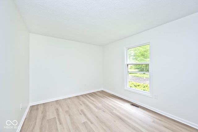 19446 Ethan Allen Ln, Westfield, IN 46074 - empty room featuring light wood-type flooring, a textured ceiling, and baseboards