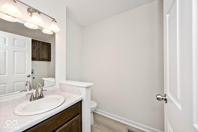 19446 Ethan Allen Ln, Westfield, IN 46074 - bathroom with toilet, vanity, wood finished floors, and baseboards