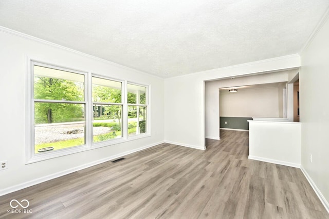 19446 Ethan Allen Ln, Westfield, IN 46074 - unfurnished living room with healthy amount of natural light, crown molding, wood finished floors, a textured ceiling, and baseboards