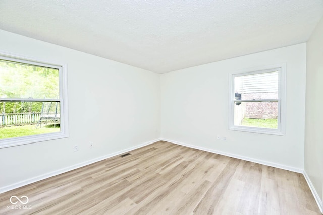 19446 Ethan Allen Ln, Westfield, IN 46074 - unfurnished room with light wood-style floors, baseboards, and a textured ceiling