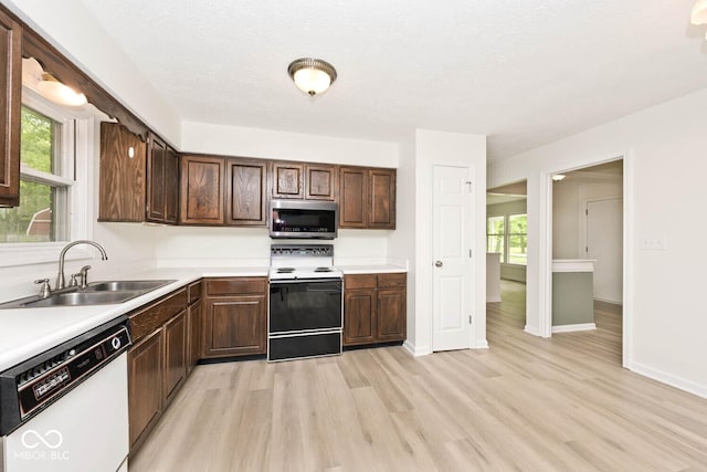 19446 Ethan Allen Ln, Westfield, IN 46074 - kitchen featuring stainless steel microwave, electric range, white dishwasher, a sink, and light wood-type flooring