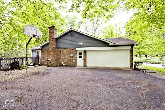 19446 Ethan Allen Ln, Westfield, IN 46074 - view of side of property featuring asphalt driveway, brick siding, an attached garage, and a chimney