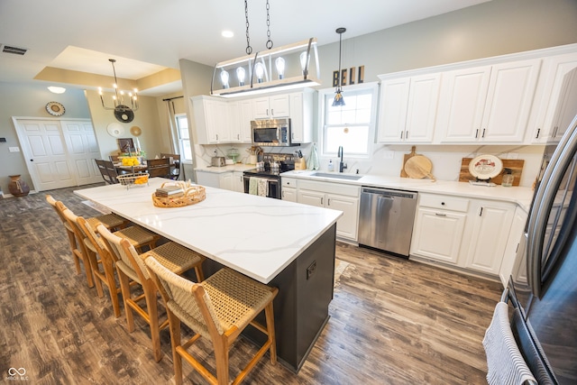 kitchen with appliances with stainless steel finishes, plenty of natural light, white cabinets, and recessed lighting