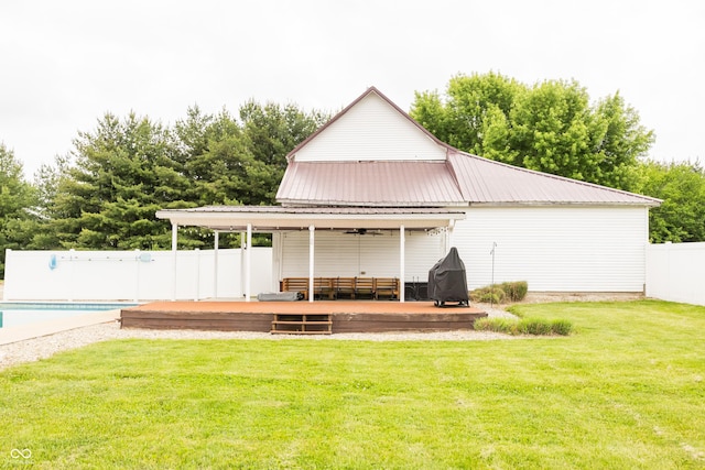 back of house with a deck, a ceiling fan, and metal roof