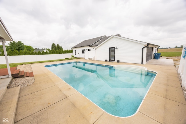 view of swimming pool featuring fence and a patio area