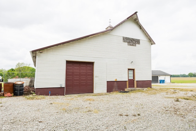view of home's exterior featuring a detached garage and fence