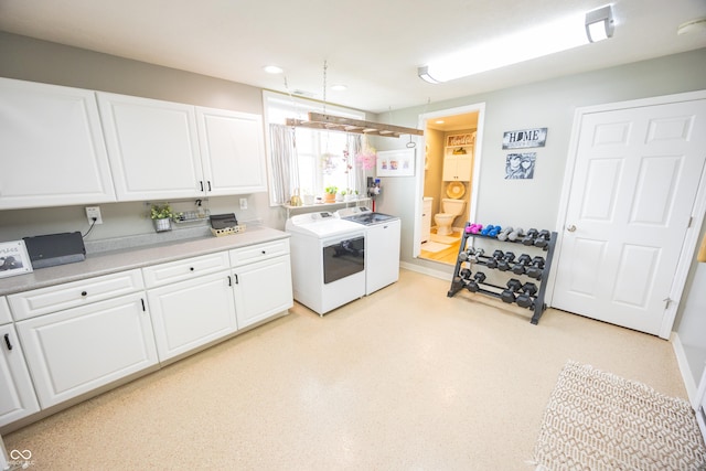 kitchen featuring independent washer and dryer, white cabinetry, light countertops, recessed lighting, and baseboards