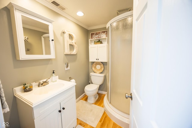 bathroom with wood finished floors, a stall shower, vanity, toilet, and ornamental molding