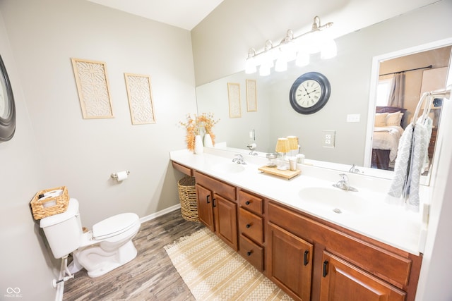 full bath featuring wood finished floors, toilet, double vanity, and baseboards