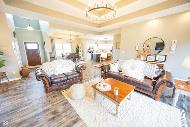 living area featuring a chandelier, wood finished floors, and baseboards