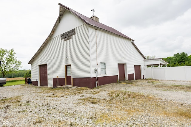 view of home's exterior with metal roof and fence