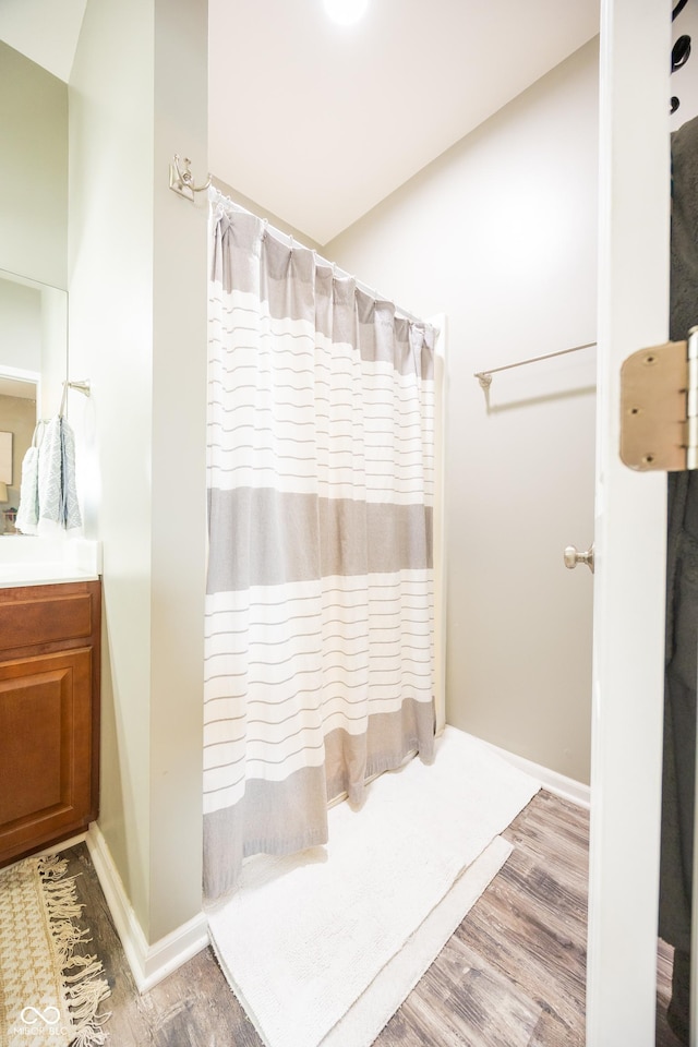 full bathroom featuring wood finished floors, vanity, baseboards, and a shower with curtain