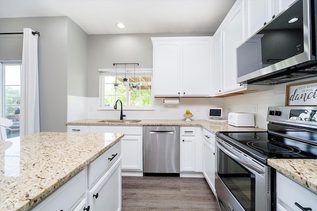 14130 Autumn Woods Dr, Carmel, IN 46074 - kitchen with appliances with stainless steel finishes, a sink, white cabinets, wood finished floors, and recessed lighting