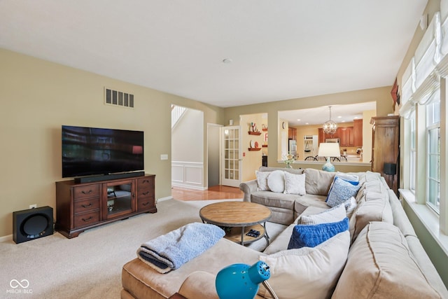 9311 Windrift Way, Zionsville, IN 46077 - living room with healthy amount of natural light, light carpet, and a chandelier
