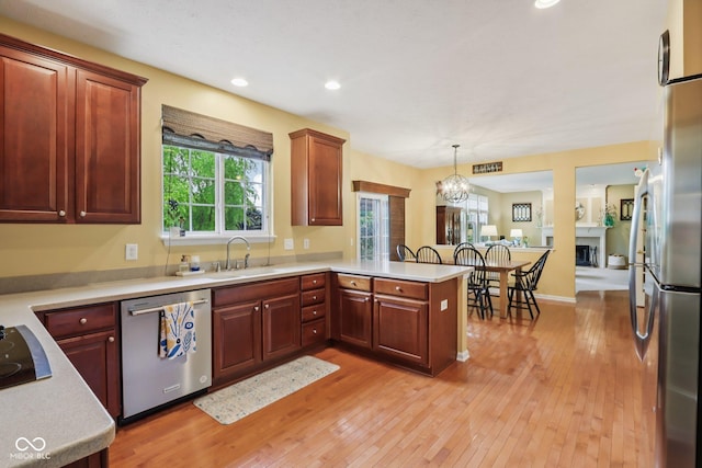 9311 Windrift Way, Zionsville, IN 46077 - kitchen with stainless steel appliances, a peninsula, light wood finished floors, light countertops, and recessed lighting