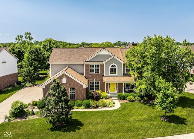 9311 Windrift Way, Zionsville, IN 46077 - traditional home featuring brick siding, a front yard, driveway, and a shingled roof