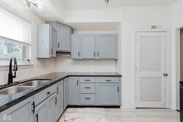 2230 Pleasant St, Indianapolis, IN 46203 - kitchen with a sink, tasteful backsplash, dark stone countertops, and gray cabinetry