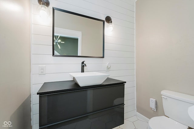 2230 Pleasant St, Indianapolis, IN 46203 - half bathroom with vanity, toilet, tile patterned floors, and wood walls
