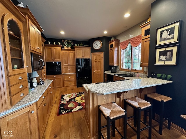 125 Ems B20C Ln, Pierceton, IN 46562 - kitchen featuring black appliances, wood finished floors, a sink, a peninsula, and recessed lighting