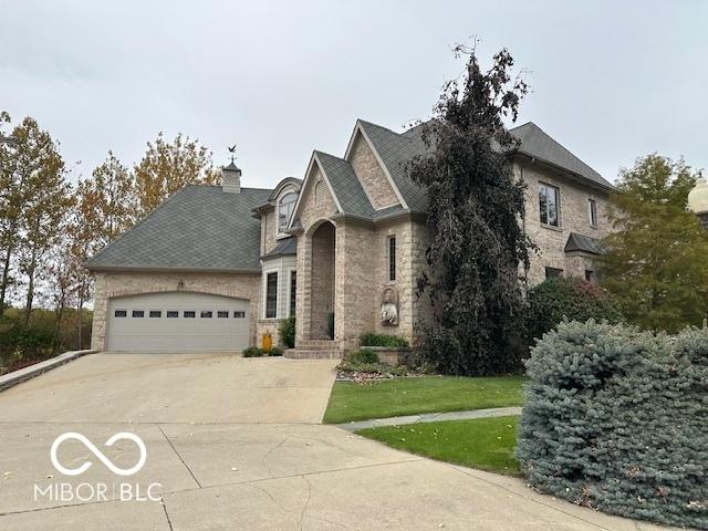 125 Ems B20C Ln, Pierceton, IN 46562 - french country inspired facade with driveway, an attached garage, stone siding, and a front lawn