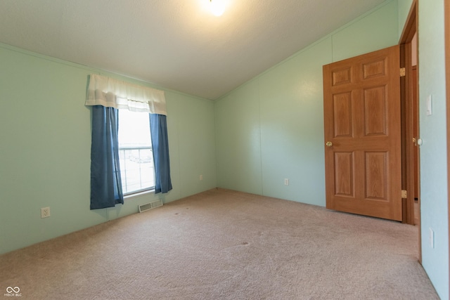 carpeted spare room featuring lofted ceiling