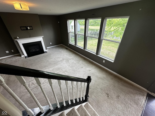 14462 Brook Meadow Dr, Mccordsville, IN 46055 - unfurnished living room featuring baseboards, a fireplace with flush hearth, and carpet floors