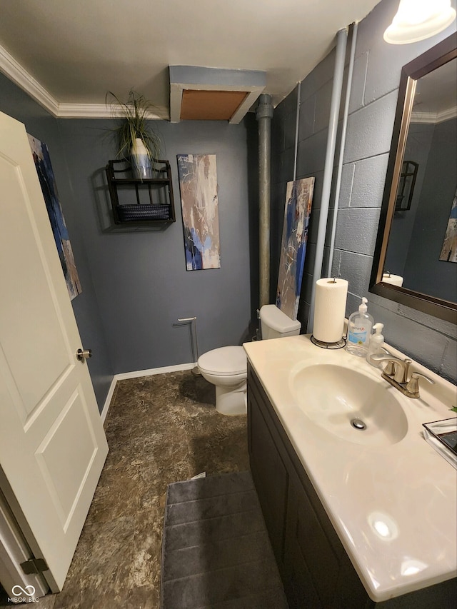 5433 Brendonridge Rd, Indianapolis, IN 46226 - bathroom featuring toilet, vanity, concrete block wall, and ornamental molding