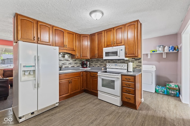 5115 Bertha St, Indianapolis, IN 46241 - kitchen featuring white appliances, washer / dryer, light wood-type flooring, brown cabinetry, and a textured ceiling