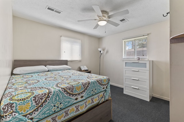5115 Bertha St, Indianapolis, IN 46241 - bedroom with multiple windows, dark carpet, a textured ceiling, ceiling fan, and baseboards